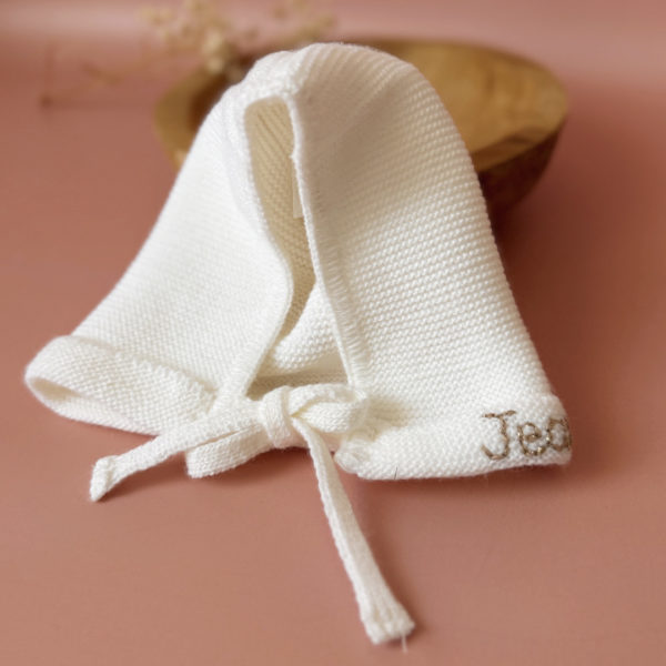 Le petit béguin de naissance, un incontournable dans la valise maternité Délicatement tricotée dans une douce laine alpaga écru, ce petit béguin respire l'élégance et la délicatesse, parfait pour les premiers jours de votre nouveau-né. Ce béguin peut être personnalisé avec le prénom de votre bébé, ajoutant une touche personnelle. Offrez à votre enfant un accessoire à la fois pratique et chargé d'émotion, idéal pour immortaliser ces précieux moments. Un cadeau parfaitement adapté pour accueillir votre petit trésor dans le monde avec tendresse et douceur. Son design simple et élégant s'accorde facilement avec toutes les tenues de bébé. Notamment avec notre douce brassière de naissance ajourée écrue.