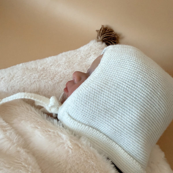 Le petit béguin de naissance, un incontournable dans la valise maternité Délicatement tricotée dans une douce laine alpaga écru, ce petit béguin respire l'élégance et la délicatesse, parfait pour les premiers jours de votre nouveau-né. Ce béguin peut être personnalisé avec le prénom de votre bébé, ajoutant une touche personnelle. Offrez à votre enfant un accessoire à la fois pratique et chargé d'émotion, idéal pour immortaliser ces précieux moments. Un cadeau parfaitement adapté pour accueillir votre petit trésor dans le monde avec tendresse et douceur. Son design simple et élégant s'accorde facilement avec toutes les tenues de bébé. Notamment avec notre douce brassière de naissance ajourée écrue.