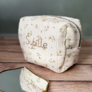 La trousse de toilette pour bébé est une pièce personnalisée et pratique, conçue avec soin pour répondre aux besoins des parents et de leur nouveau-né. Vous serez conquis par son grand format. La conception de la trousse permet aux produits de bébé de tenir debout à l'intérieur, ce qui facilite l'organisation et l'accès aux produits essentiels. Liniment, couches, lait de toilette, cotons, autant de produits pour un si petit bout de chou, que vous aurez besoin d'une grande trousse de toilette spacieuse. Fabriquée en gaze de coton matelassée, cette trousse est à la fois douce et durable. L'intérieur de la trousse est doublé avec un tissu imperméable. Les liquides renversés ne pénètrent pas à l'extérieur, protégeant ainsi les autres articles dans le sac. Personnaliser votre trousse de toilette, au doux prénom de bébé ! La personnalisation est réalisée à la main sur le devant de la trousse de toilette. Fièrement fabriquée en France, cette trousse de toilette est le fruit d'un savoir-faire artisanal et d'une attention particulière aux détails. Zoom sur le petit curseur de la fermeture à glissière ! Découvrez notre gamme entière de produits de ce thème: langes, couvertures, doudous lange...