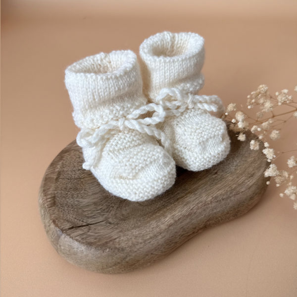 Les premiers jours de bébé sont précieux, et chaque détail compte pour assurer son confort et sa chaleur. Les chaussons en maille tricot réchaufferont les petits pieds de votre tout-petit pour ces premiers jours. Tricoté avec soin cette laine apporte de la chaleur, une légèreté, un fil chaud , doux et léger. Ils sont fabriqués dans l’un de nos ateliers partenaires français. Nous préconisons ces petits chaussons pour les naissances qui auront lieu au beaux jours ( de mai à septembre) . Grâce à sa texture et à sa conception, nos chaussons de naissance maintiennent la chaleur corporelle de votre bébé au niveau de ces petits pieds.  Offrez à votre bébé le confort et la chaleur dont il a besoin  en complétant son trousseau de naissance avec un petit bonnet. Un cadeau parfaitement adapté pour accueillir votre petit trésor dans le monde avec tendresse et douceur. Vous pouvez également compléter ce petit look de naissance avec l’une de nos brassières douce et chaude en maille.
