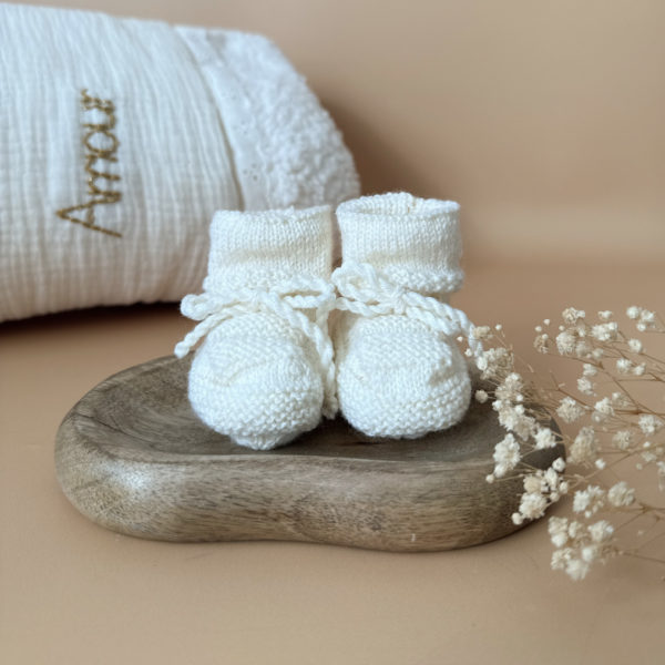 Les premiers jours de bébé sont précieux, et chaque détail compte pour assurer son confort et sa chaleur. Les chaussons en maille tricot réchaufferont les petits pieds de votre tout-petit pour ces premiers jours. Tricoté avec soin cette laine apporte de la chaleur, une légèreté, un fil chaud , doux et léger. Ils sont fabriqués dans l’un de nos ateliers partenaires français. Nous préconisons ces petits chaussons pour les naissances qui auront lieu au beaux jours ( de mai à septembre) . Grâce à sa texture et à sa conception, nos chaussons de naissance maintiennent la chaleur corporelle de votre bébé au niveau de ces petits pieds.  Offrez à votre bébé le confort et la chaleur dont il a besoin  en complétant son trousseau de naissance avec un petit bonnet. Un cadeau parfaitement adapté pour accueillir votre petit trésor dans le monde avec tendresse et douceur. Vous pouvez également compléter ce petit look de naissance avec l’une de nos brassières douce et chaude en maille.
