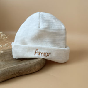 Le bonnet de naissance personnalisé pour bébé en maille velours côtelé est l'accessoire idéal pour les premiers jours de votre nouveau-né. Confectionné avec soin dans une maille éponge côtelée , ce bonnet offre à votre bébé douceur et confort incomparables. Il est fabriqué dans l’un de nos ateliers partenaires français. Un cadeau parfaitement adapté pour accueillir votre petit trésor dans le monde avec tendresse et douceur. Retrouvez dans la même gamme, nos petits chaussons de naissance. Grâce à sa texture, ce bonnet maintient la chaleur corporelle de votre bébé, de sorte que celui-ci sera bien au chaud pendant ses premiers jours. Ce bonnet peut être personnalisé avec le prénom de votre bébé, ce qui en fait un cadeau unique et attentionné. Offrez à votre bébé le confort et la chaleur dont il a besoin avec ce bonnet de naissance personnalisé en maille éponge côtelée. Un cadeau parfaitement adapté pour accueillir votre petit trésor dans le monde avec tendresse et douceur. Son design simple et élégant s'accorde facilement avec toutes les tenues de bébé. Notamment avec notre douce brassière de naissance ajourée écrue.