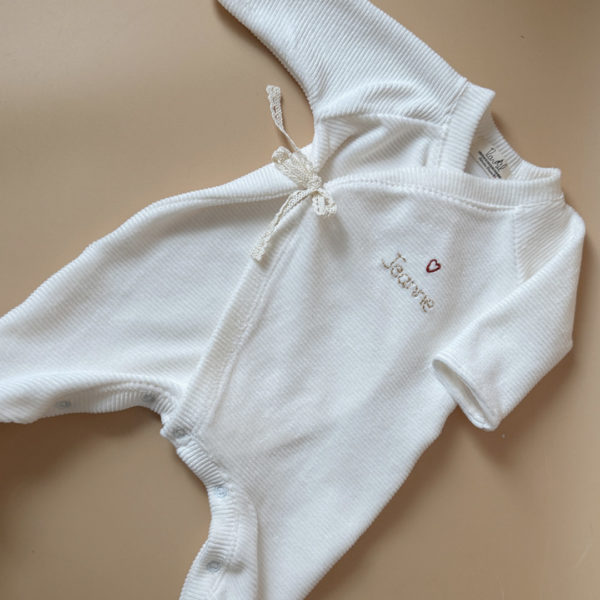 Offrez à votre nouveau-né un confort absolu avec notre pyjama de naissance écru en mini maille côtelée, soigneusement fabriqué en France. Ce pyjama allie douceur et praticité, idéal pour les premiers mois de bébé. Son design élégant en maille de velours côtelé offre une texture agréable au toucher, tandis que sa teinte écrue apporte une touche intemporelle. Il se distingue par sa personnalisation au prénom de votre enfant, en faisant un cadeau unique et inoubliable. Pratique, il est doté d'une fermeture sur le devant pour faciliter l'habillage, ainsi qu'une ouverture intégrale au niveau des pieds, rendant le changement de couches simple et rapide. Un incontournable pour le trousseau de naissance, conçu pour offrir à votre bébé le meilleur dès ses premiers jours. Un cadeau parfaitement adapté pour accueillir votre petit trésor dans le monde avec tendresse et douceur. Retrouvez dans la même gamme, nos petits chaussons de naissance ainsi que nos bonnets.