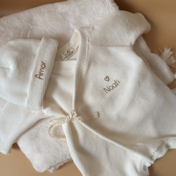 Offrez à votre nouveau-né un confort absolu avec notre pyjama de naissance écru en mini maille côtelée, soigneusement fabriqué en France. Ce pyjama allie douceur et praticité, idéal pour les premiers mois de bébé. Son design élégant en maille de velours côtelé offre une texture agréable au toucher, tandis que sa teinte écrue apporte une touche intemporelle. Il se distingue par sa personnalisation au prénom de votre enfant, en faisant un cadeau unique et inoubliable. Pratique, il est doté d'une fermeture sur le devant pour faciliter l'habillage, ainsi qu'une ouverture intégrale au niveau des pieds, rendant le changement de couches simple et rapide. Un incontournable pour le trousseau de naissance, conçu pour offrir à votre bébé le meilleur dès ses premiers jours. Un cadeau parfaitement adapté pour accueillir votre petit trésor dans le monde avec tendresse et douceur. Retrouvez dans la même gamme, nos petits chaussons de naissance ainsi que nos bonnets.