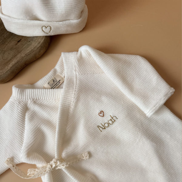 Offrez à votre nouveau-né un confort absolu avec notre pyjama de naissance écru en mini maille côtelée, soigneusement fabriqué en France. Ce pyjama allie douceur et praticité, idéal pour les premiers mois de bébé. Son design élégant en maille de velours côtelé offre une texture agréable au toucher, tandis que sa teinte écrue apporte une touche intemporelle. Il se distingue par sa personnalisation au prénom de votre enfant, en faisant un cadeau unique et inoubliable. Pratique, il est doté d'une fermeture sur le devant pour faciliter l'habillage, ainsi qu'une ouverture intégrale au niveau des pieds, rendant le changement de couches simple et rapide. Un incontournable pour le trousseau de naissance, conçu pour offrir à votre bébé le meilleur dès ses premiers jours. Un cadeau parfaitement adapté pour accueillir votre petit trésor dans le monde avec tendresse et douceur. Retrouvez dans la même gamme, nos petits chaussons de naissance ainsi que nos bonnets.
