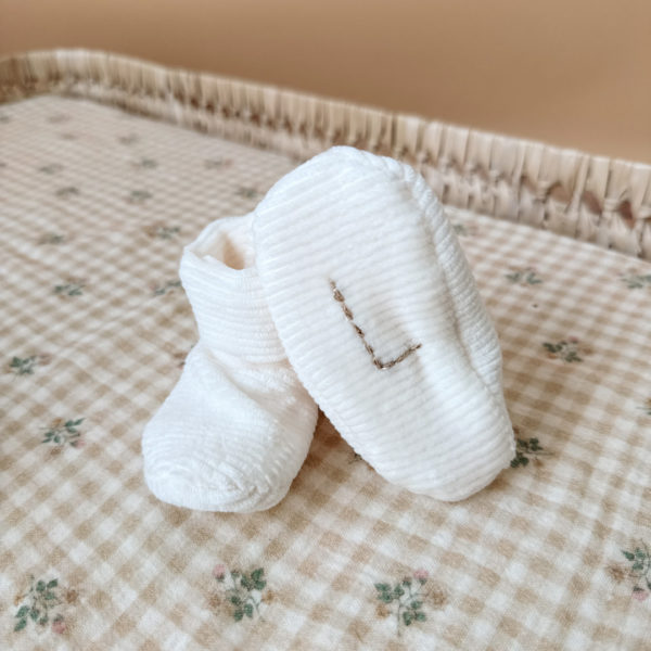 Les premiers jours de bébé sont précieux, et chaque détail compte pour assurer son confort et sa chaleur. Les chaussons en maille éponge côtelée réchaufferont les petits pieds de votre tout-petit pour ces premiers jours. Confectionné avec soin dans une maille éponge côtelée, ils offrent à votre bébé douceur et confort incomparables. Ils sont fabriqués dans l’un de nos ateliers partenaires français. Un cadeau parfaitement adapté pour accueillir votre petit trésor dans le monde avec tendresse et douceur. Grâce à sa texture et à sa conception, nos chaussons de naissance maintiennent la chaleur corporelle de votre bébé au niveau de ces petits pieds.  Offrez à votre bébé le confort et la chaleur dont il a besoin  en complétant son trousseau de naissance avec un petit bonnet en velours côtelé de la même gamme. Un cadeau parfaitement adapté pour accueillir votre petit trésor dans le monde avec tendresse et douceur. Vous pouvez également compléter ce petit look de naissance avec le pyjama assorti ou bien  l’une de nos brassières douce et chaude en maille.