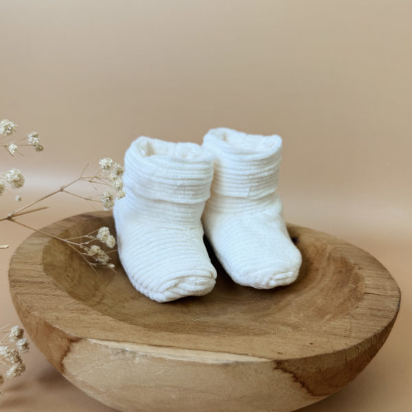 Les premiers jours de bébé sont précieux, et chaque détail compte pour assurer son confort et sa chaleur. Les chaussons en maille éponge côtelée réchaufferont les petits pieds de votre tout-petit pour ces premiers jours. Confectionné avec soin dans une maille éponge côtelée, ils offrent à votre bébé douceur et confort incomparables. Ils sont fabriqués dans l’un de nos ateliers partenaires français. Un cadeau parfaitement adapté pour accueillir votre petit trésor dans le monde avec tendresse et douceur. Grâce à sa texture et à sa conception, nos chaussons de naissance maintiennent la chaleur corporelle de votre bébé au niveau de ces petits pieds.  Offrez à votre bébé le confort et la chaleur dont il a besoin  en complétant son trousseau de naissance avec un petit bonnet en velours côtelé de la même gamme. Un cadeau parfaitement adapté pour accueillir votre petit trésor dans le monde avec tendresse et douceur. Vous pouvez également compléter ce petit look de naissance avec le pyjama assorti ou bien  l’une de nos brassières douce et chaude en maille.