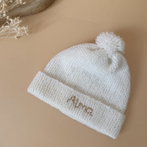 Le bonnet de naissance personnalisé pour bébé en maille tricotée de coton est l'accessoire idéal pour les premiers jours de votre nouveau-né. Confectionné avec soin, ce bonnet offre à votre bébé douceur et confort incomparables. Il est fabriqué dans l’un de nos ateliers partenaires français. Un cadeau parfaitement adapté pour accueillir votre petit trésor dans le monde avec tendresse et douceur. Retrouvez dans la même gamme, nos petits chaussons de naissance. Grâce à sa texture et à sa conception, ce bonnet maintient la chaleur corporelle de votre bébé, de sorte que celui-ci sera bien au chaud pendant ses premiers jours.  Extra chaud, il est tricoté à la main dans une laine spéciale layette 100% laine mérinos. 
