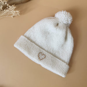 e bonnet de naissance personnalisé pour bébé en maille tricotée de coton est l'accessoire idéal pour les premiers jours de votre nouveau-né. Confectionné avec soin, ce bonnet offre à votre bébé douceur et confort incomparables. Il est fabriqué dans l’un de nos ateliers partenaires français. Un cadeau parfaitement adapté pour accueillir votre petit trésor dans le monde avec tendresse et douceur. Retrouvez dans la même gamme, nos petits chaussons de naissance. Grâce à sa texture et à sa conception, ce bonnet maintient la chaleur corporelle de votre bébé, de sorte que celui-ci sera bien au chaud pendant ses premiers jours.  Extra chaud, il est tricoté à la main dans une laine spéciale layette 100% laine mérinos. 