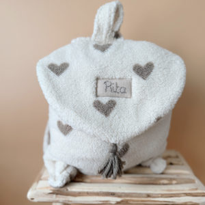 Adoptez notre tout nouveau sac à dos, il est idéal pour emporter le change, le biberon, la gourde, le départ pour la crèche, la nounou mais aussi les premiers pas pour l'école ! Il est tout doux, tout mou et tout léger pour prendre soin du dos de votre enfant. Il est réalisé en fausse fourrure sherpa,  ouatiné , dans nos ateliers français. Notre emblématique pompon vient habillé le petit rabat qui est lui même muni d'une pression. Les anses sont ajustables en réglant les petits nœuds. Fabriqué en sherpa  tout doux, il assure le confort de votre bébé tout en étant doux et léger au porter;. Doté de bretelles réglables et d'une poignée de transport pratique, ce sac à dos est parfaitement adapté à la morphologie de votre enfant et offre une grande facilité d'utilisation. Idéal pour les sorties en famille, les promenades au parc ou les voyages, ce sac à dos offre suffisamment d'espace pour ranger les essentiels de bébé tout en restant léger et compact.