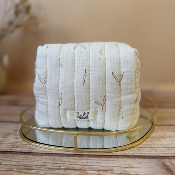 La trousse de toilette pour bébé est une pièce personnalisée et pratique, conçue avec soin pour répondre aux besoins des parents et de leur nouveau-né. Vous serez conquis par son grand format. La conception de la trousse permet aux produits de bébé de tenir debout à l'intérieur, ce qui facilite l'organisation et l'accès aux produits essentiels. Liniment, couches, lait de toilette, cotons, autant de produits pour un si petit bout de chou, que vous aurez besoin d'une grande trousse de toilette spacieuse. Fabriquée en gaze de coton matelassée, cette trousse est à la fois douce et durable. L'intérieur de la trousse est doublé avec un tissu imperméable. Les liquides renversés ne pénètrent pas à l'extérieur, protégeant ainsi les autres articles dans le sac. Personnaliser votre trousse de toilette, au doux prénom de bébé ! La personnalisation est réalisée à la main sur le devant de la trousse de toilette. Fièrement fabriquée en France, cette trousse de toilette est le fruit d'un savoir-faire artisanal et d'une attention particulière aux détails. Zoom sur le petit curseur de la fermeture à glissière ! Découvrez notre gamme entière de produits de ce thème: langes, couvertures, doudous lange...