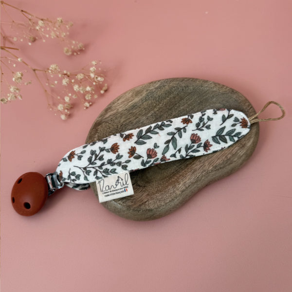 Élégante, douce et sécurisée, notre attache tétine en gaze de coton écrue accompagne bébé au quotidien tout en ajoutant une touche délicate à sa tenue. Chaque modèle est personnalisable avec le prénom de bébé, soigneusement brodé à la main, pour créer un accessoire unique et plein de sens. Dotée d’un lien doré raffiné pour fixer la tétine et d’une pince ronde en silicone embossé, elle allie esthétique et praticité.