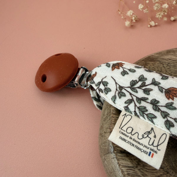 Élégante, douce et sécurisée, notre attache tétine en gaze de coton écrue accompagne bébé au quotidien tout en ajoutant une touche délicate à sa tenue. Chaque modèle est personnalisable avec le prénom de bébé, soigneusement brodé à la main, pour créer un accessoire unique et plein de sens. Dotée d’un lien doré raffiné pour fixer la tétine et d’une pince ronde en silicone embossé, elle allie esthétique et praticité.