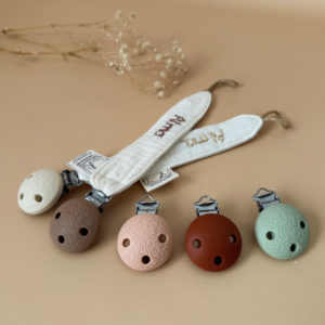 Élégante, douce et sécurisée, notre attache tétine en gaze de coton écrue accompagne bébé au quotidien tout en ajoutant une touche délicate à sa tenue. Chaque modèle est personnalisable avec le prénom de bébé, soigneusement brodé à la main, pour créer un accessoire unique et plein de sens. Dotée d’un lien doré raffiné pour fixer la tétine et d’une pince ronde en silicone embossé, elle allie esthétique et praticité.