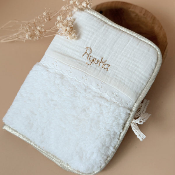 Pour protéger le carnet de santé tout en douceur et lui offrir une jolie enveloppe, voici l'accessoire qui rend les visites chez le médecin un peu plus gaies ! Fermeture au côté avec un joli lien en dentelle de coton.  Il est réalisé en fausse fourrure sherpa écrue avec notre jolie galon dentelle anglaise et gaze de coton. Son contour et biaisé par un ruban doré.