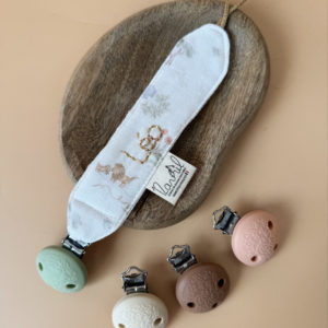 Élégante, douce et sécurisée, notre attache tétine en gaze de coton  accompagne bébé au quotidien tout en ajoutant une touche délicate à sa tenue. Chaque modèle est personnalisable avec le prénom de bébé, soigneusement brodé à la main, pour créer un accessoire unique et plein de sens. Dotée d’un lien doré raffiné pour fixer la tétine et d’une pince ronde en silicone embossé, elle allie esthétique et praticité.