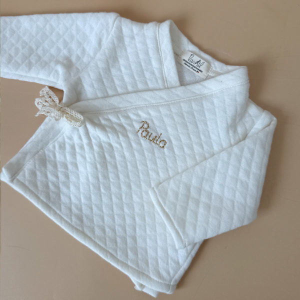 Offrez à votre bébé un premier vêtement doux, élégant et entièrement fabriqué en France avec cet adorable ensemble de naissance en coton matelassé écru. Composé d’une brassière croisée et d’un pantalon assorti, cet ensemble enveloppe bébé de confort dès ses premiers jours.