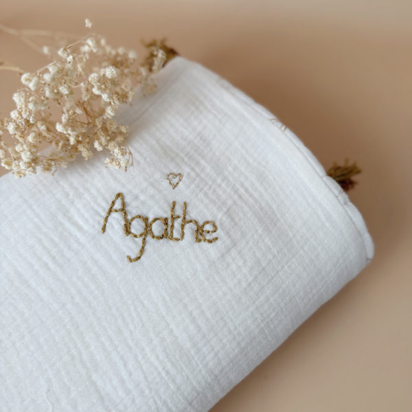 Découvrez la couverture idéale pour accompagner votre bébé pendant les beaux jours. Confectionnée en gaze de coton écrue et en gaze de coton matelassée aux délicats motifs feuillage doré, cette couverture allie douceur, légèreté et élégance.