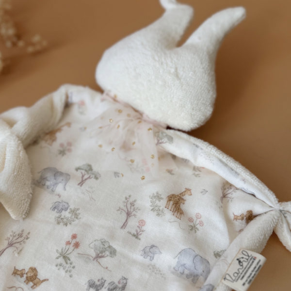 Offrez à votre bébé un compagnon de douceur avec ce magnifique doudou lange en forme de lapin, confectionné en 100% coton avec notre micro éponge écrue et un doux motif printanier en gaze de coton. Ce doudou, aussi mignon que réconfortant, deviendra vite l’allié idéal des moments câlins et des siestes. son petit plus : un lien attache tétine ! 
