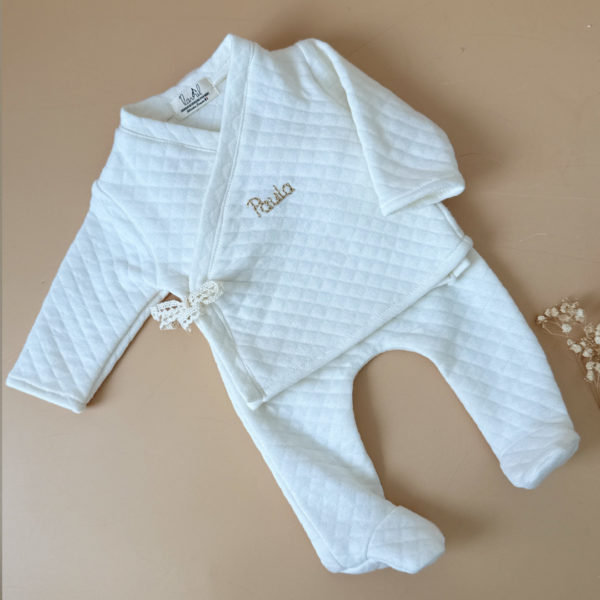 Offrez à votre bébé un premier vêtement doux, élégant et entièrement fabriqué en France avec cet adorable ensemble de naissance en coton matelassé écru. Composé d’une brassière croisée et d’un pantalon assorti, cet ensemble enveloppe bébé de confort dès ses premiers jours.
